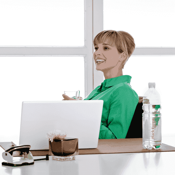 Junge Frau lacht und trinkt Black Forest still