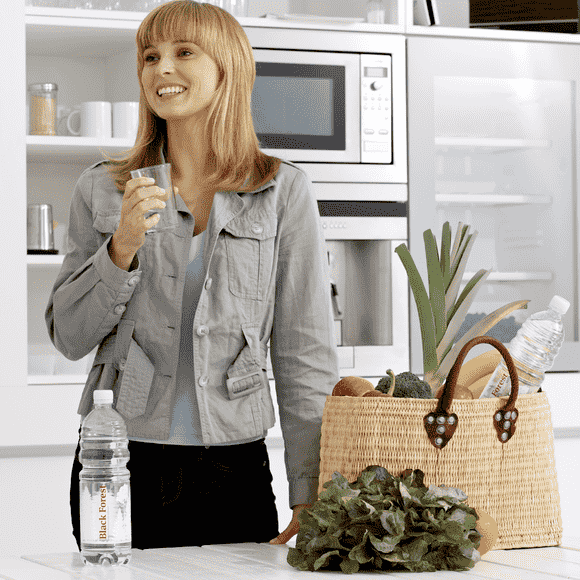 Junge Frau trinkt ein Glas Black Forest still